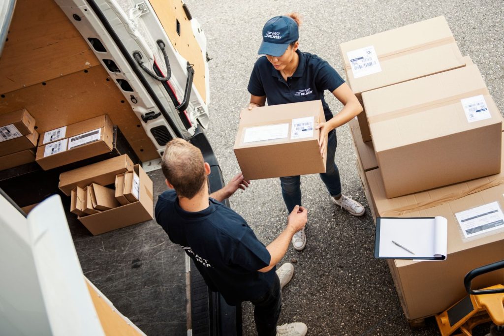 a delivery woman and man with brown boxes surrounding them